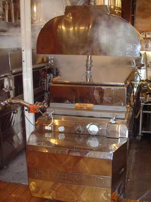 steam rises from a maple sap evaporator
